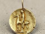 a close up of a gold coin with a man and a dog on it