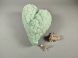 a green heart shaped piece of soap next to a small piece of wood