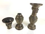 three vases and a bowl sitting on a table
