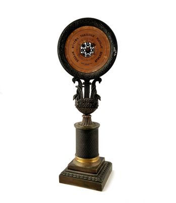 une horloge posée sur un socle, sur fond blanc