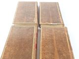 three old books sitting on top of each other on a white surface