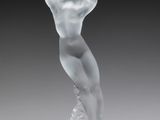 une photo d'une sculpture en verre représentant une femme posée sur un socle