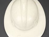 a white hard hat on a plate on a table