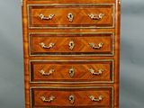 une commode ancienne avec des bordures dorées sur les tiroirs