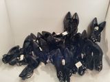 de nombreuses paires de chaussures noires qui traînent par terre