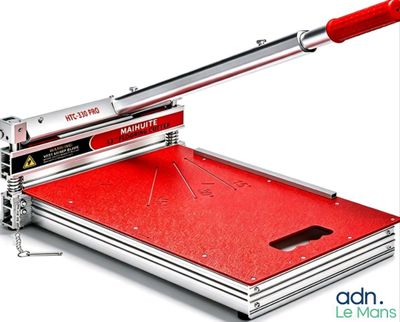 a close up of a paper cutter with a red handle