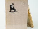 an old book with a drawing of a woman sitting on a chair
