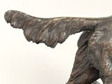 bronze statue of a dog running with a ball in its mouth