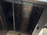 a silver oven with a door open on a tiled floor