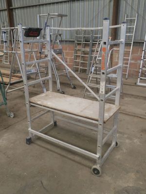 un chariot métallique muni d'un siège en bois, au milieu d'un bâtiment