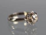 a close up of a diamond ring on a reflective surface