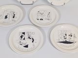six white plates with cartoon drawings on them on a white surface