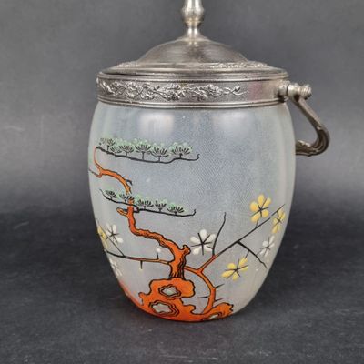 an image of a glass jar with a silver lid and a painting on it