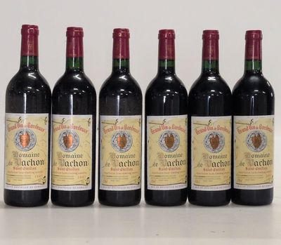 six bouteilles de vin sont alignées sur une table