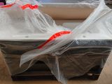 two mattresses wrapped in plastic on a pallet