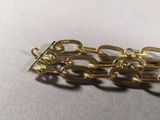 a close up of a gold chain bracelet on a table