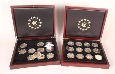 deux boîtes en bois contenant des pièces d'argent et d'or, posées sur une surface blanche