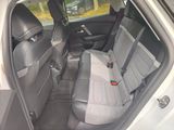 the back seats of a white car with a black seat belt