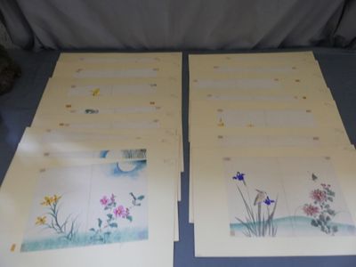 Deux tableaux représentant des fleurs sont posés sur une table recouverte d'une nappe bleue.