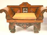 a wooden chair with a yellow cushion on top of it