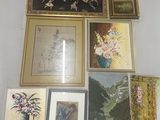 many framed pictures and paintings on the wall in this room