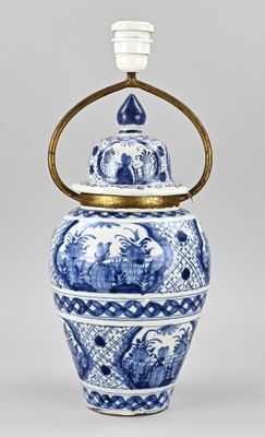 blue and white vase with a brass handle on a gray background