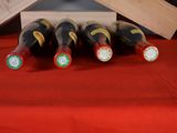 several bottles of wine sit on a table with a red table cloth
