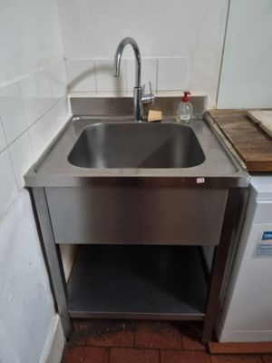 un évier en inox et une machine à laver dans une cuisine