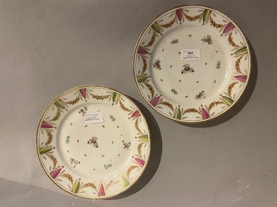 two plates with floral designs on them are sitting on a table
