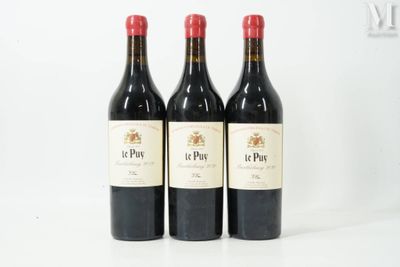 trois bouteilles de vin rouge posées sur une table blanche