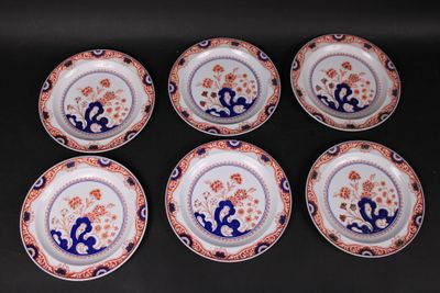 six plates with blue and orange designs on them sitting on a black surface
