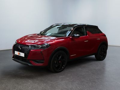 un SUV rouge garé dans une pièce aux murs blancs