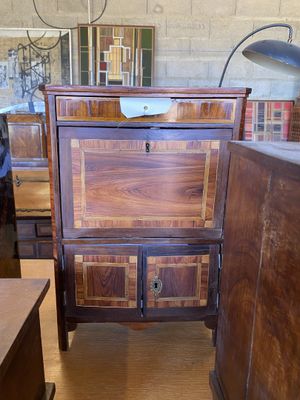 une commode en bois sur laquelle est posée une lampe