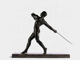 bronze sculpture of a man holding a sword on a marble base