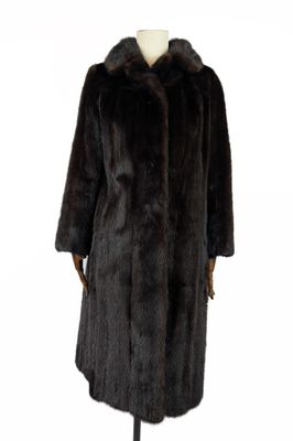 un manteau de fourrure noir posé sur un support de mannequin