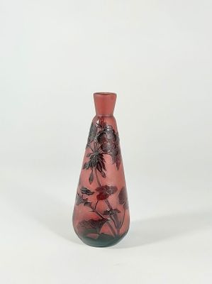 a red vase with black flowers on it on a white background