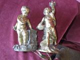 two figurines that are sitting on a purple cloth