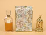 un petit flacon de parfum à côté d'une petite boîte de parfum