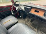 a red car with black leather seats and a wooden dash board