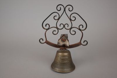 une cloche en métal surmontée d'un oiseau