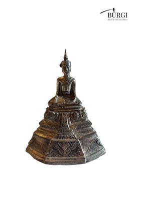 a silver statue of a buddha sitting on top of a pyramid