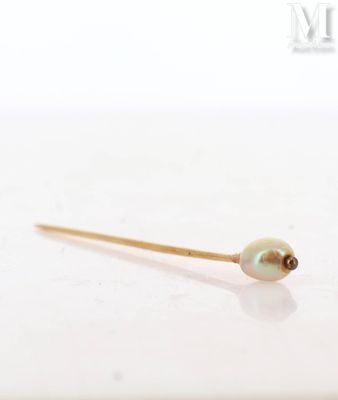 a gold stick with a pearl on it sitting on top of a table