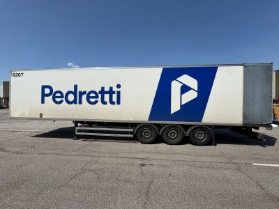 the semi trailer is parked in a parking lot with a blue and white logo on the side
