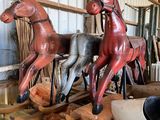three wooden horses that are sitting on a pallet