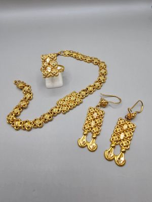un gros plan sur un collier, des boucles d'oreilles et une bague posés sur une table