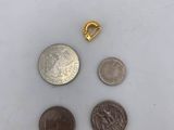 three coins and a gold clasp on a white surface
