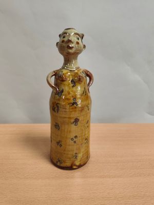 un petit vase orné d'un singe, posé sur une table