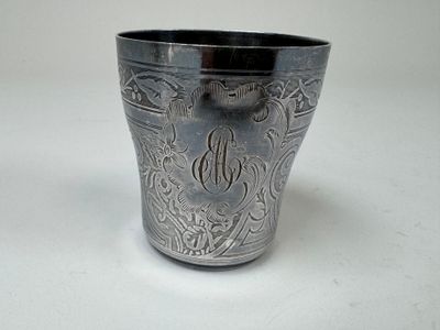 une coupe en argent posée sur une table, sur laquelle figure un monogramme