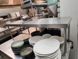 de nombreuses assiettes et bols posés sur le plan de travail de la cuisine