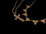 a close up of a gold necklace on a black background